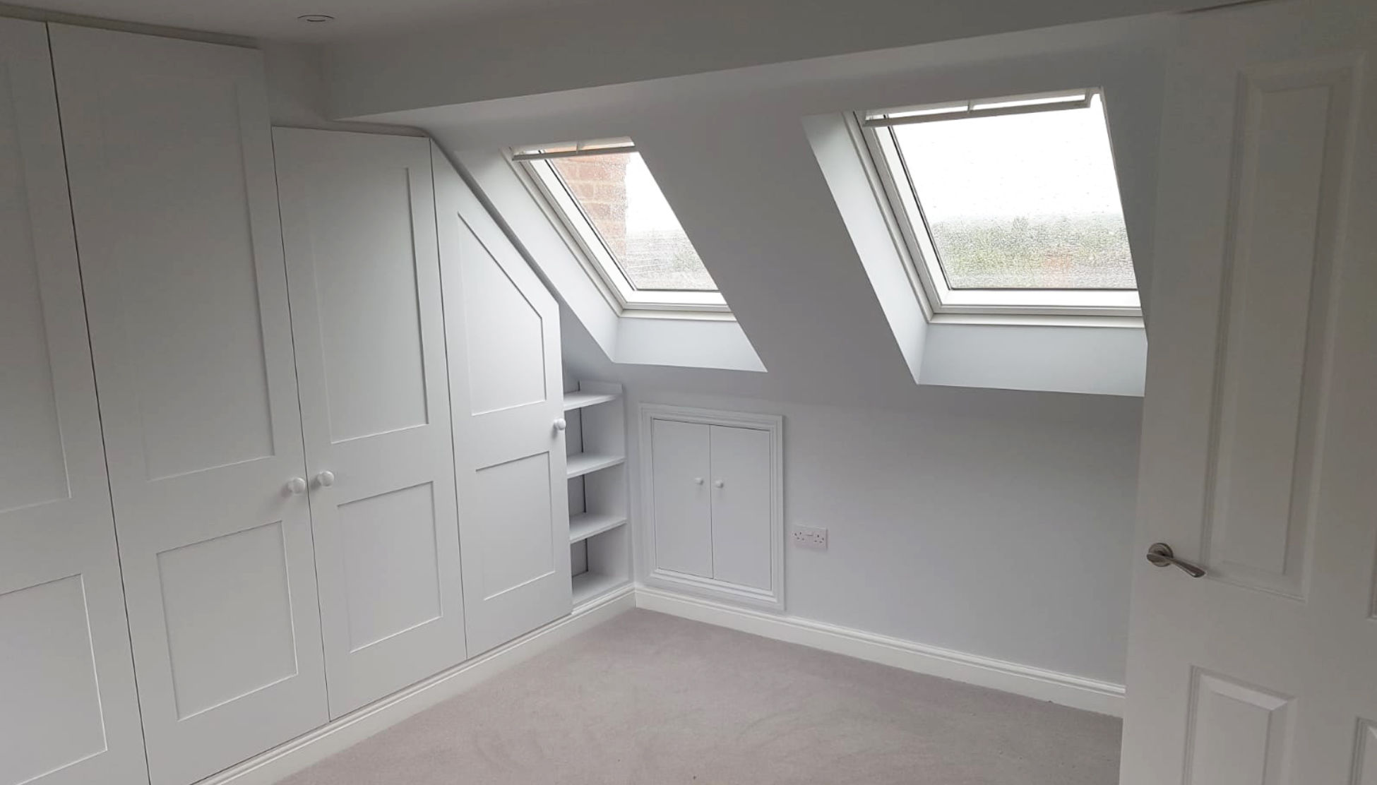 Room showing a storage unit built into eaves